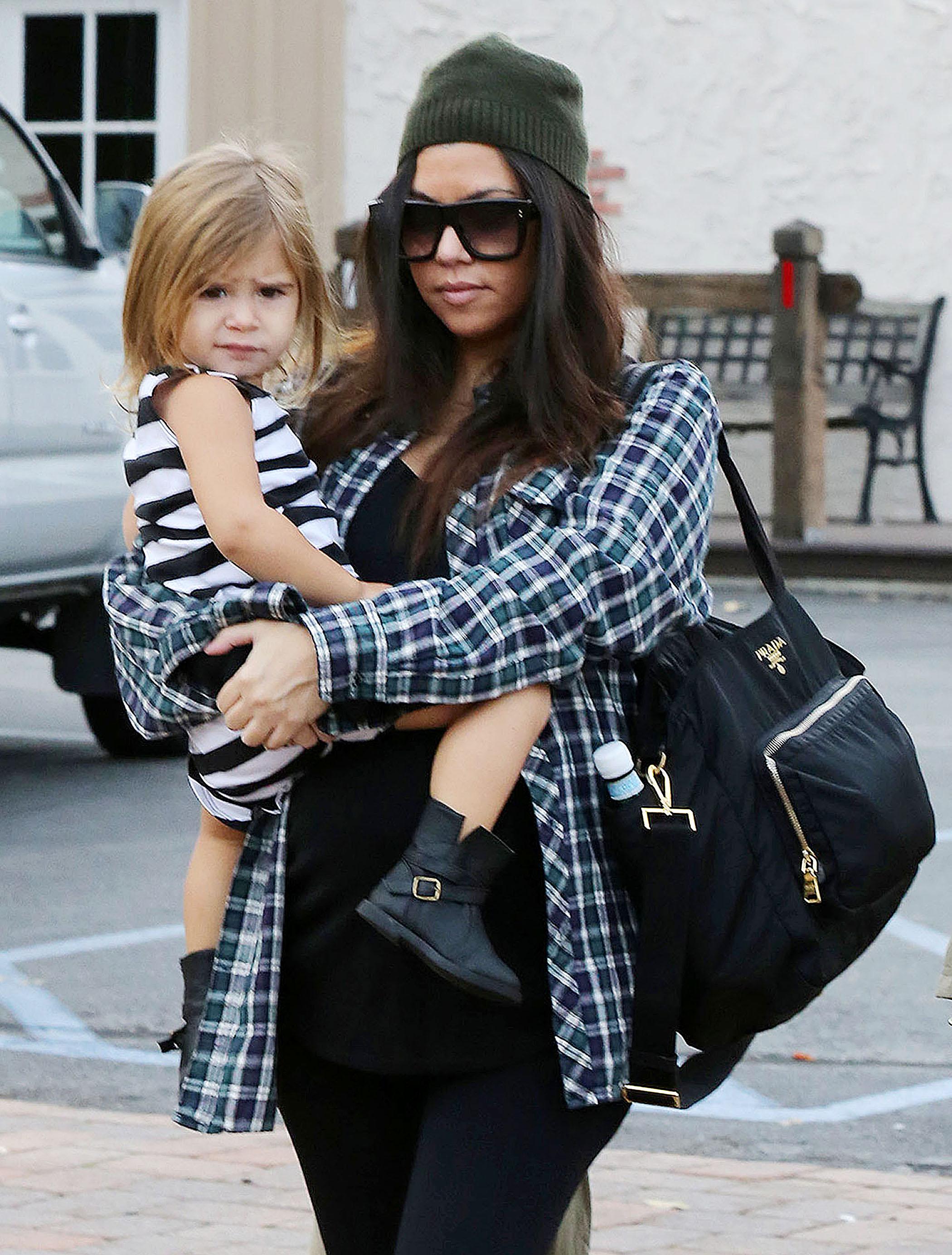 Kourtney Kardashian carrying a Prada diaper bag, takes her