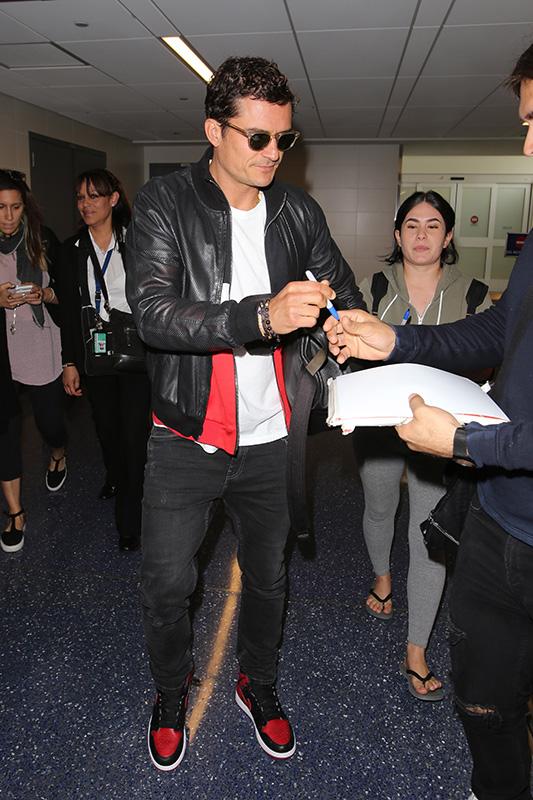 Orlando Bloom signs autographs arriving at LAX