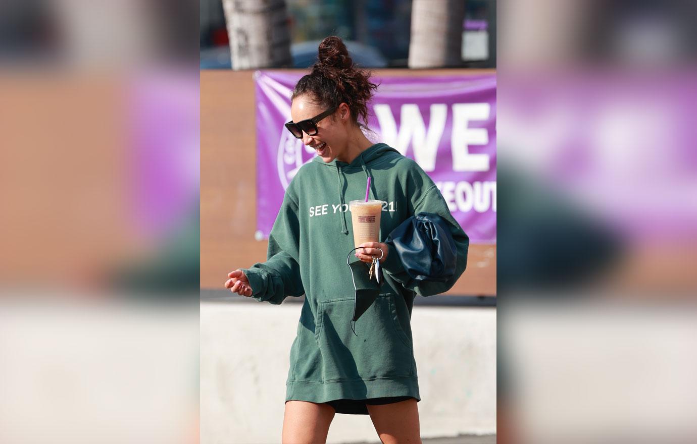 Cara Santana rocks a “see you in ‘21” Hoodie as she grabs an iced coffee after the gym. The top Made by Thirty Seconds of Mars