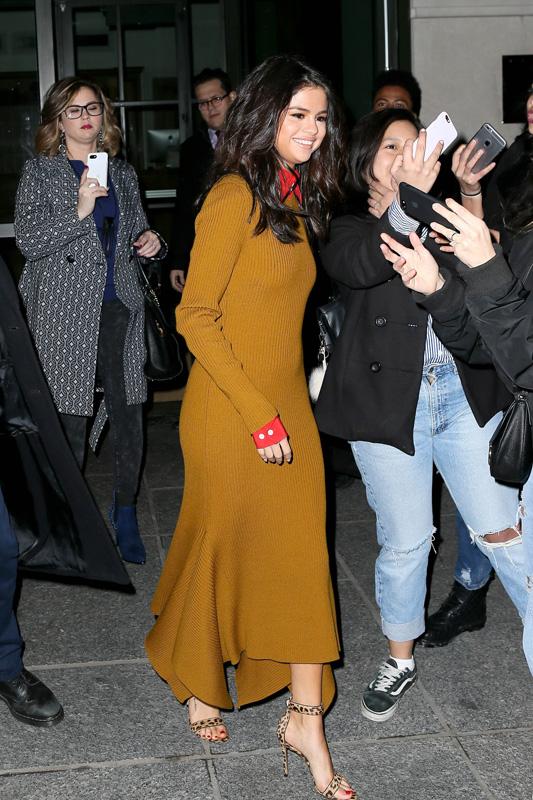 Selena Gomez greets fans as she exits an AmFar event