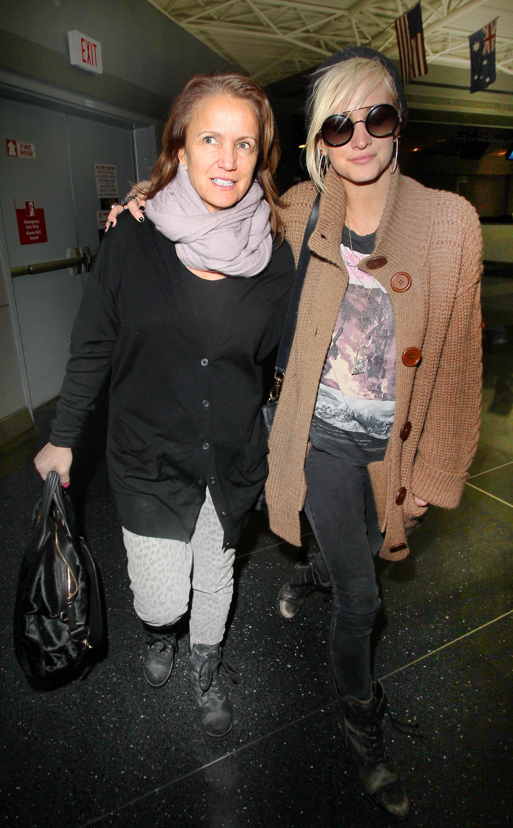 Ashlee Simpson and mother Tina Simpson hug all the way through the American Airlines terminal in New York City