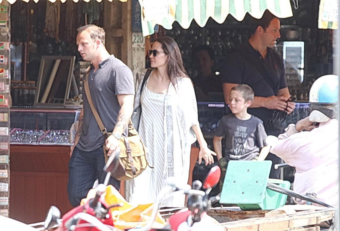 Angelina Jolie is all smiles as she steps out in Cambodia with a handsome mystery man, who has also been bonding with her six young children and buying her jewelry.