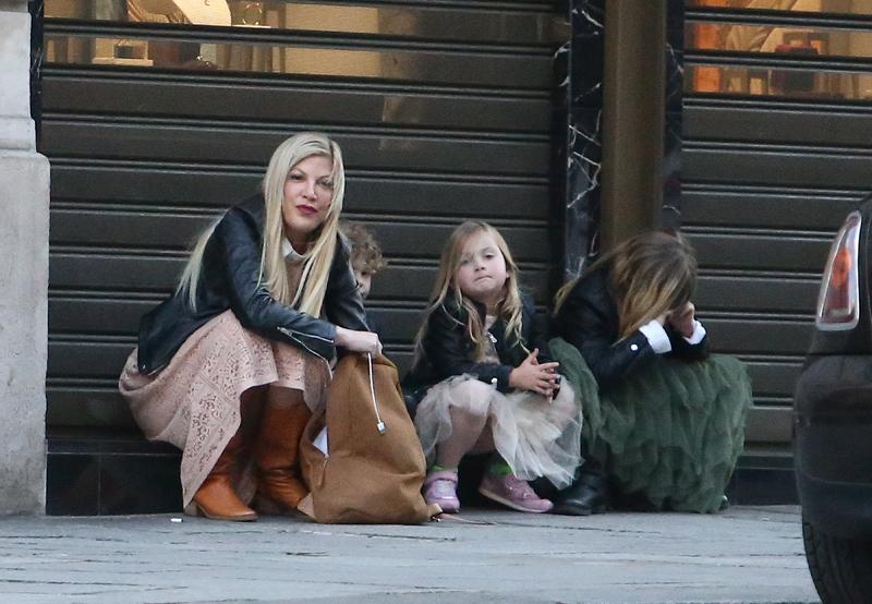 Tori Spelling waiting for taxi in Paris with kids