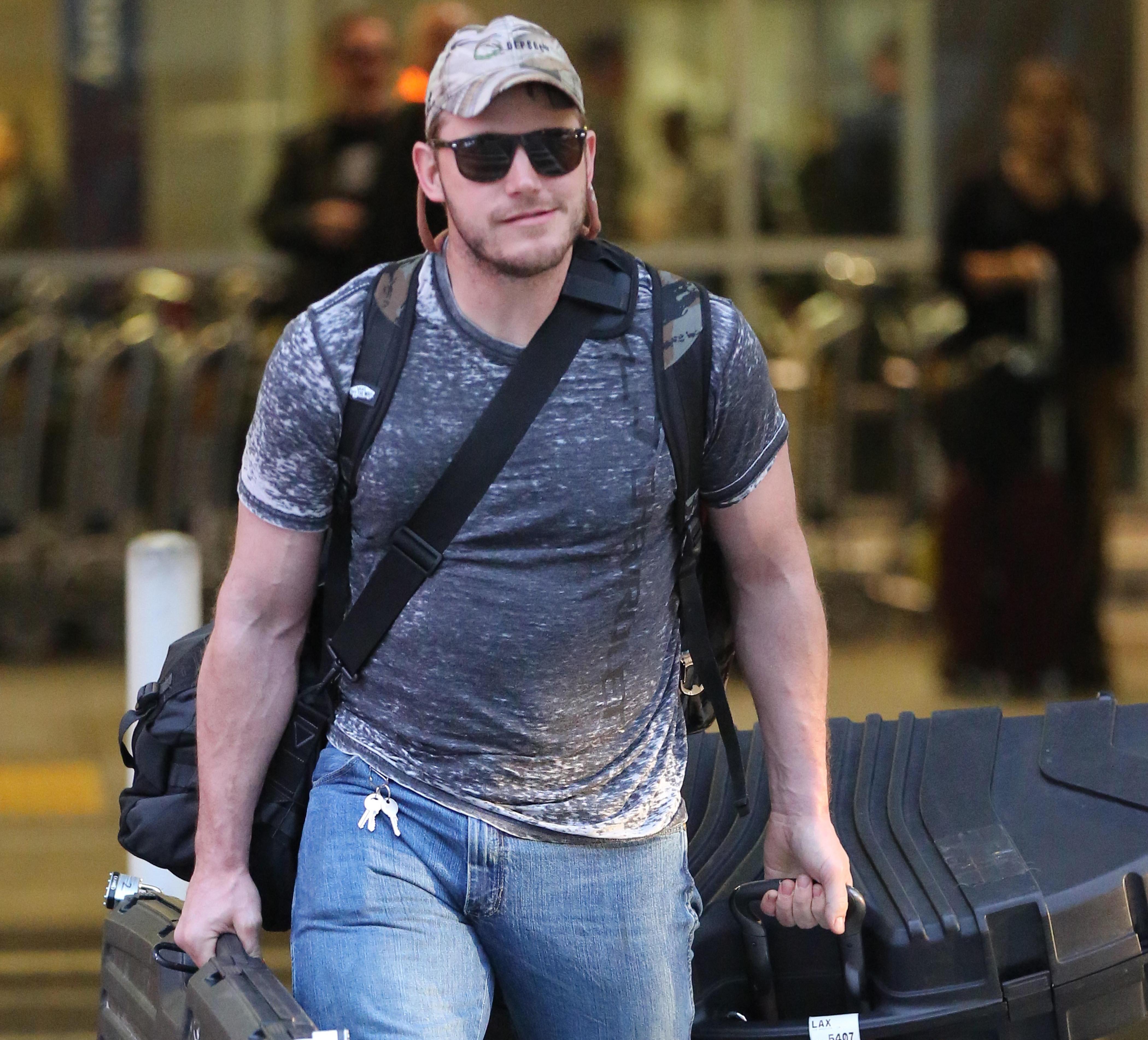 Chris Pratt shows his rugged side wearing camouflage, blue jeans and a camouflage hat as he arrives in Los Angeles