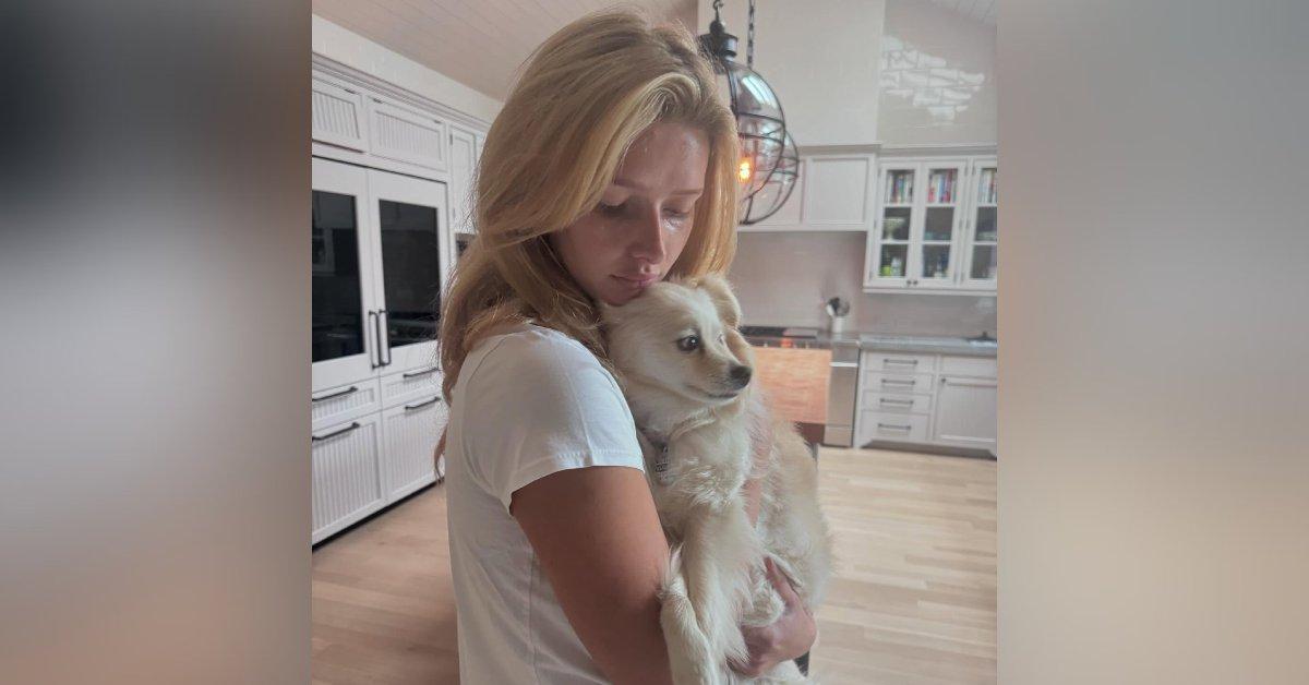 Photo of Apple Martin holding a dog.