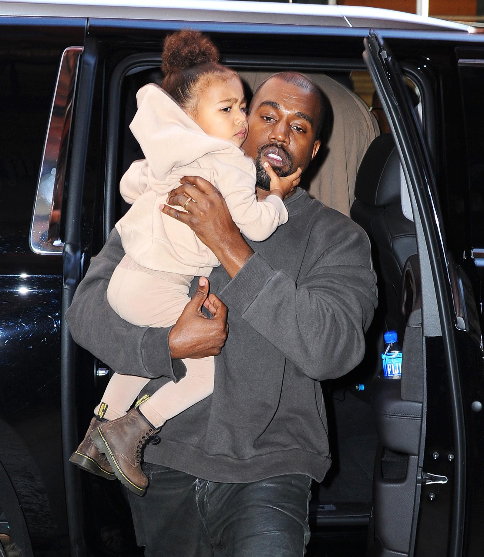 Kanye West enters The Mercer Hotel carrying daughter North West after his Yeezy show in NYC