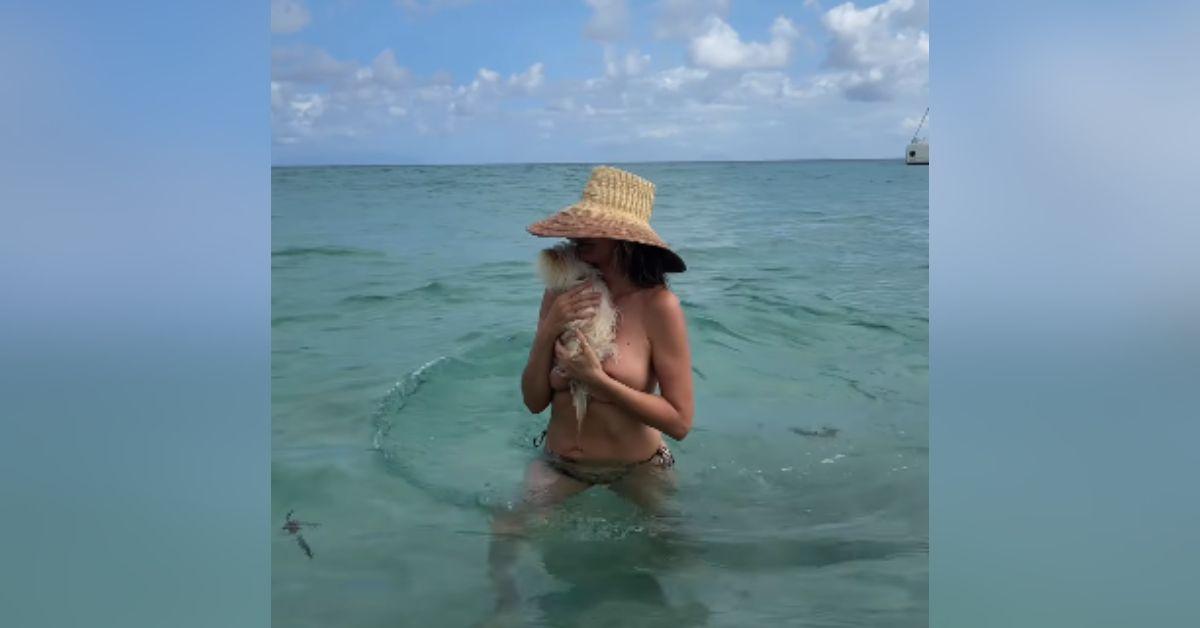 image of Heidi Klum shared topless beach photos from her tropical vacation while enjoying the ocean with her beloved dog, Fritz.