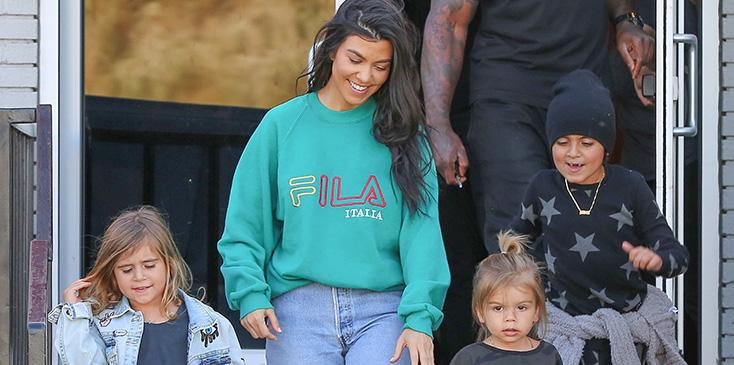 Kourtney Kardashian grins from ear to ear as she leaves the bowling alley with her family