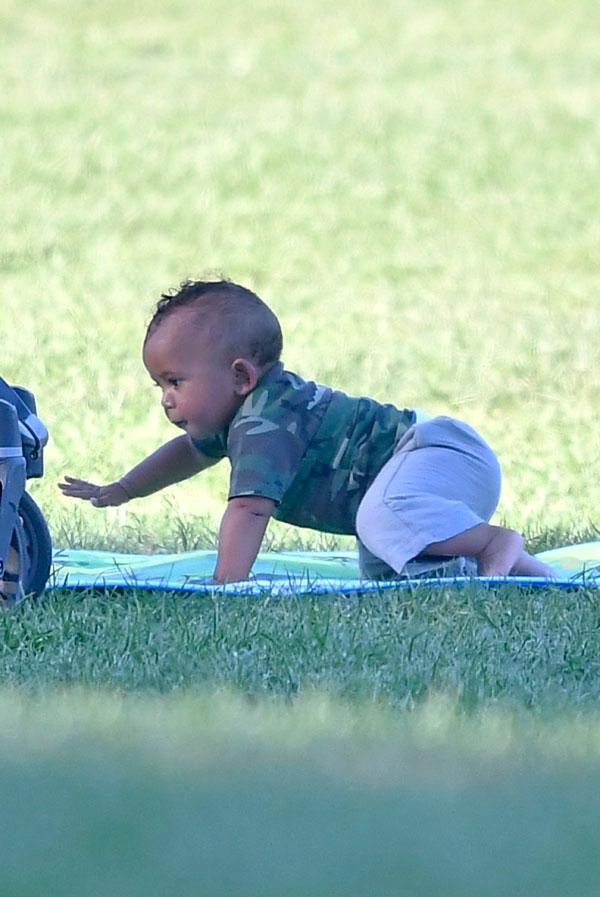 saint west smelling shoe laughing having fun in the park