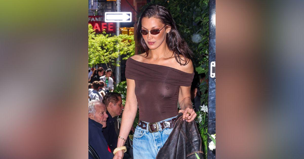 image of Bella Hadid wore a brown trench coat with wide-leg jeans, flats and a sleek ponytail for the outing.