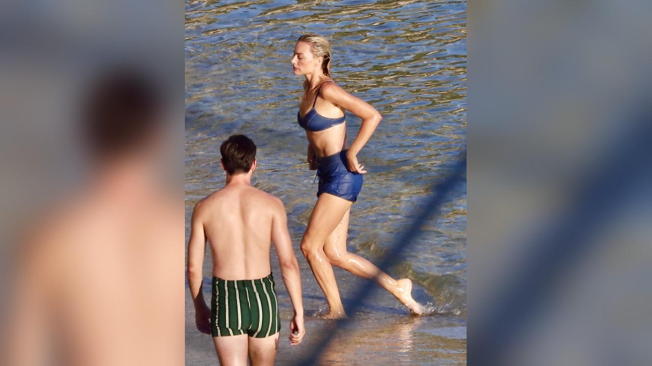 Image of Margot Robbie ran through the water while filming a beach scene alongside costar Bradley Cooper.