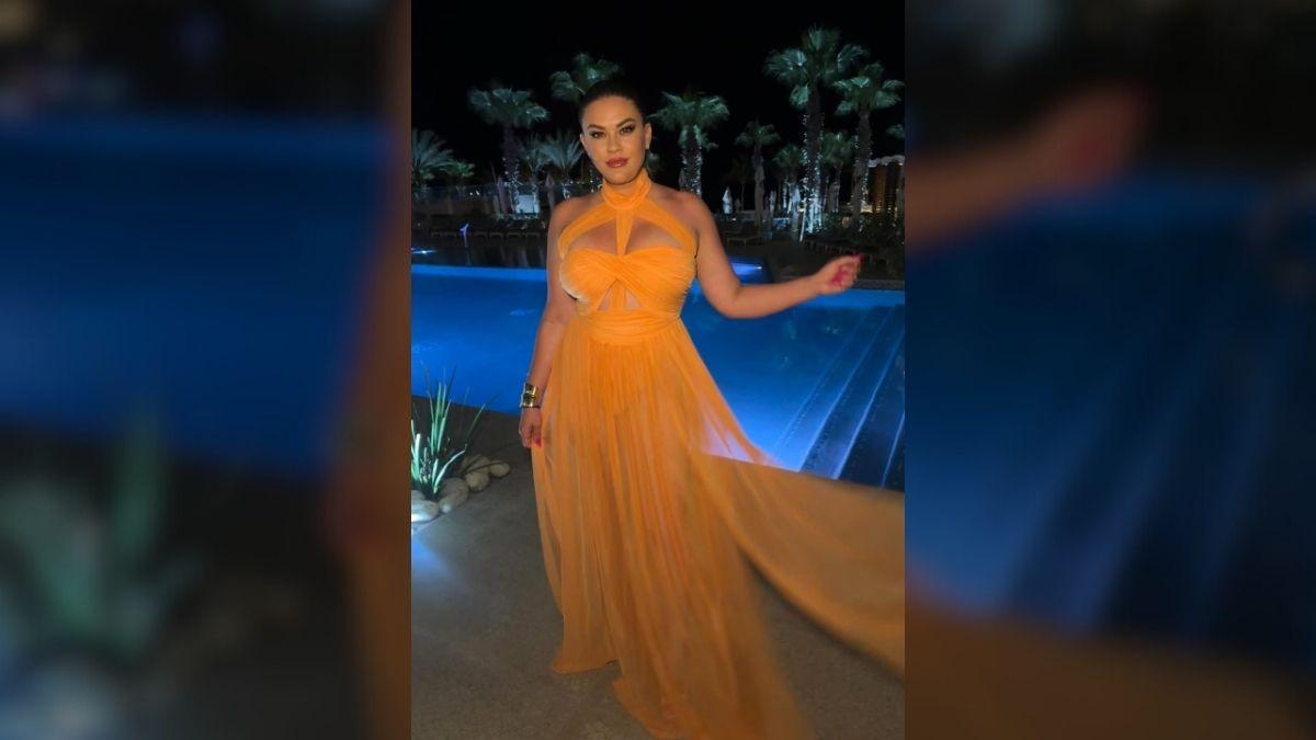 Photo of Brittany Cartwright posed in a neon orange maxi gown that featured racy cut-outs. 