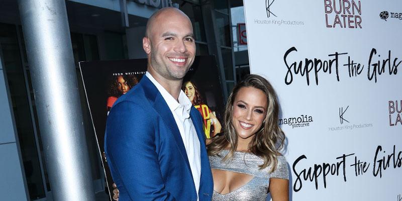 Mike Caussin waering Blue suit and White Shirt With Wife Jana Kramer Wearing Silver cut out Gown