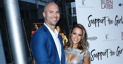 Mike Caussin waering Blue suit and White Shirt With Wife Jana Kramer Wearing Silver cut out Gown