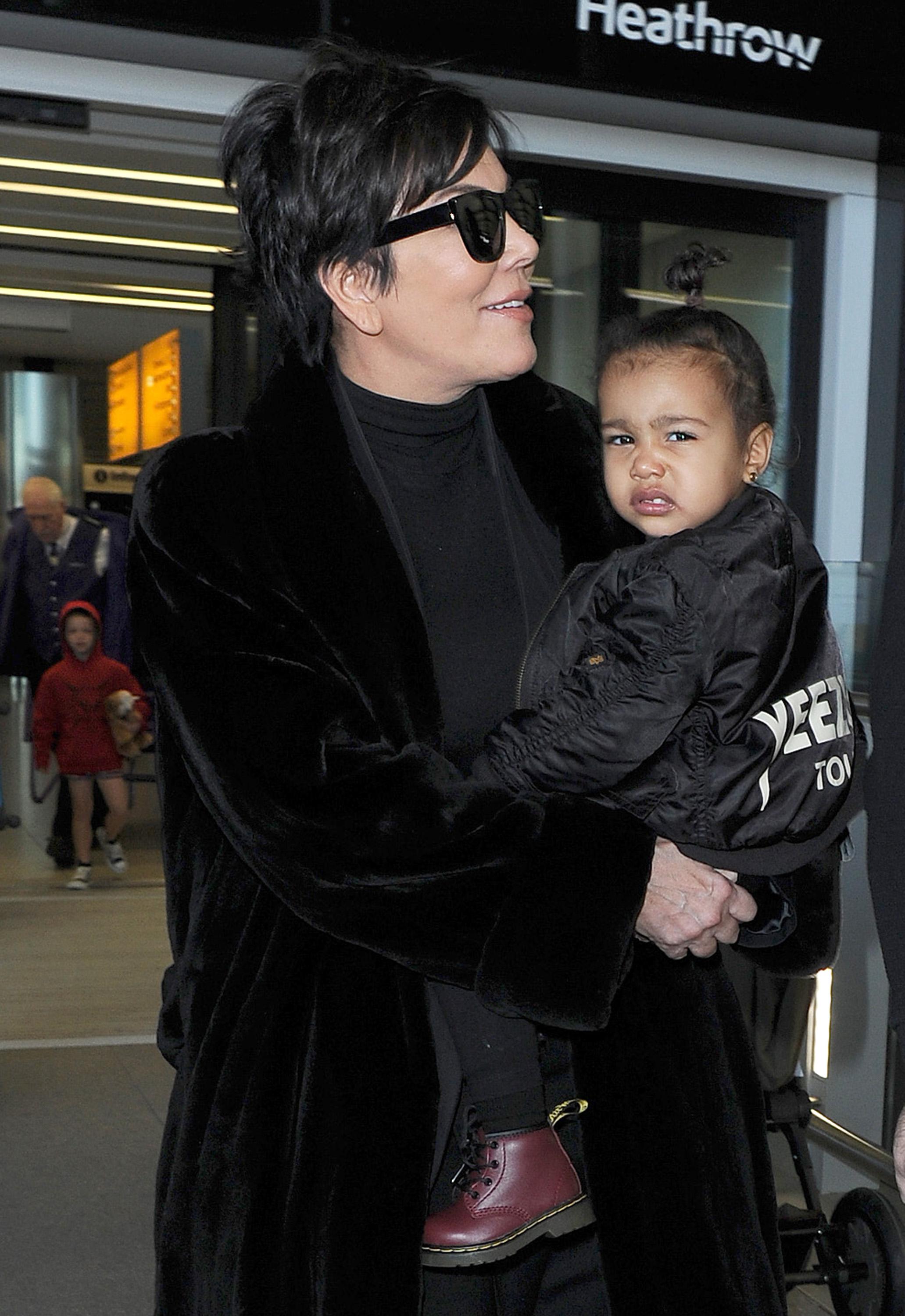 Kris Jenner arrives at Heathrow Airport, carrying baby North West, who was wearing a &#8220;Yeezus&#8221; bomber jacket to support her father Kanye