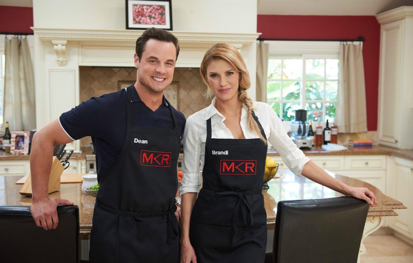 Brandi Glanville and Dean Sheremet pose wearing aprons for the TV show My Kitchen Rules on FOX.