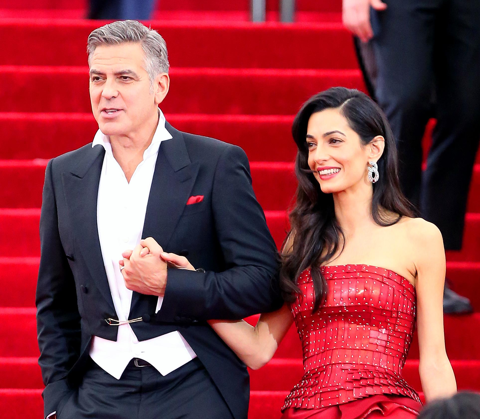 George Clooney and wife Amal Clooney lock arms as they leave the Met Gala