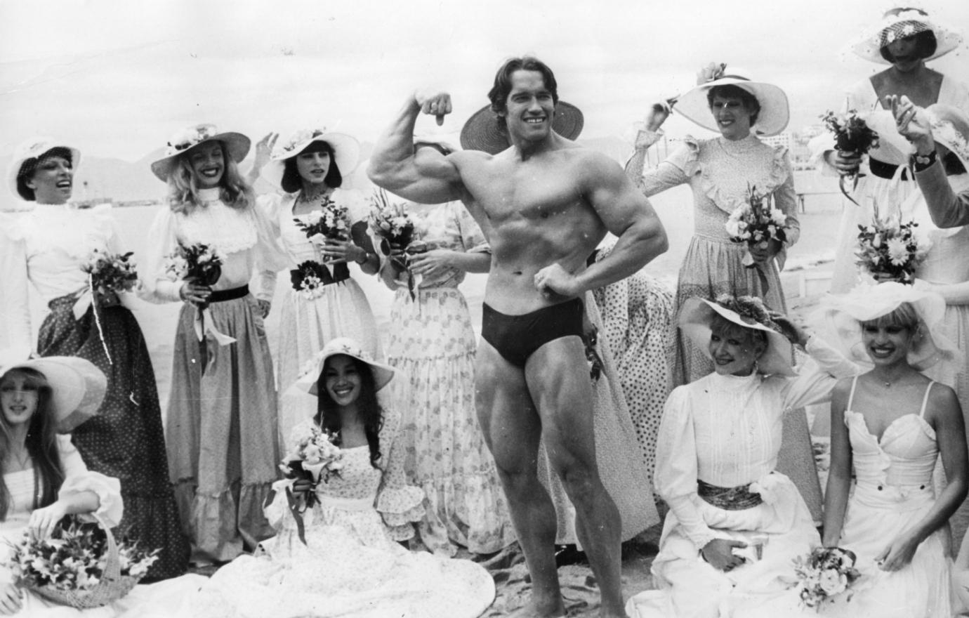 Champion weightlifter Arnold Schwarzenegger held court at the Cannes Film Festival as the reigning Mr. Universe, surrounded by the “Folies Bergere” girls. The weightlifter soon returned to the fabled French city as a movie star.