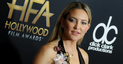 Kate Hudson wears a black dress with plunglng neckline and flower accents at the 2016 Hollywood Film Awards.