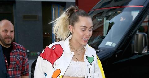 Miley Cyrus adds a pop of color to her ensemble with hand painted rainbows and balloons