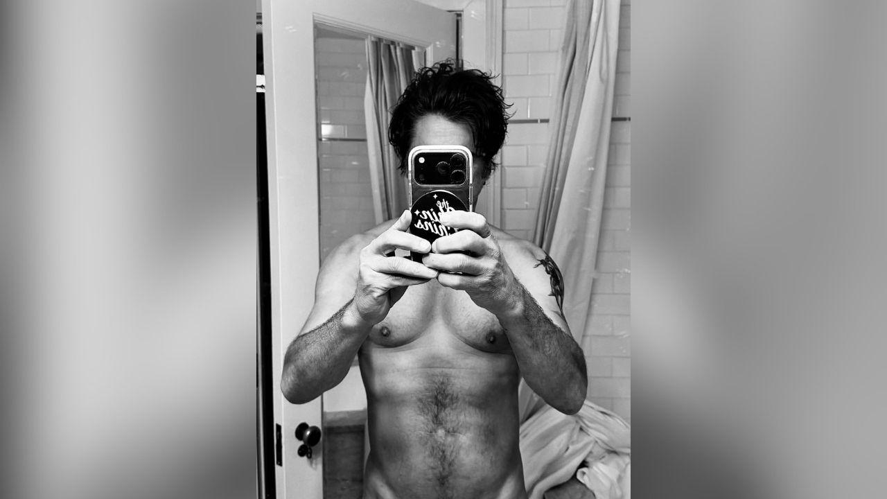 image of John Stamos celebrated his 63rd birthday by sharing a black-and-white shirtless selfie on Instagram.