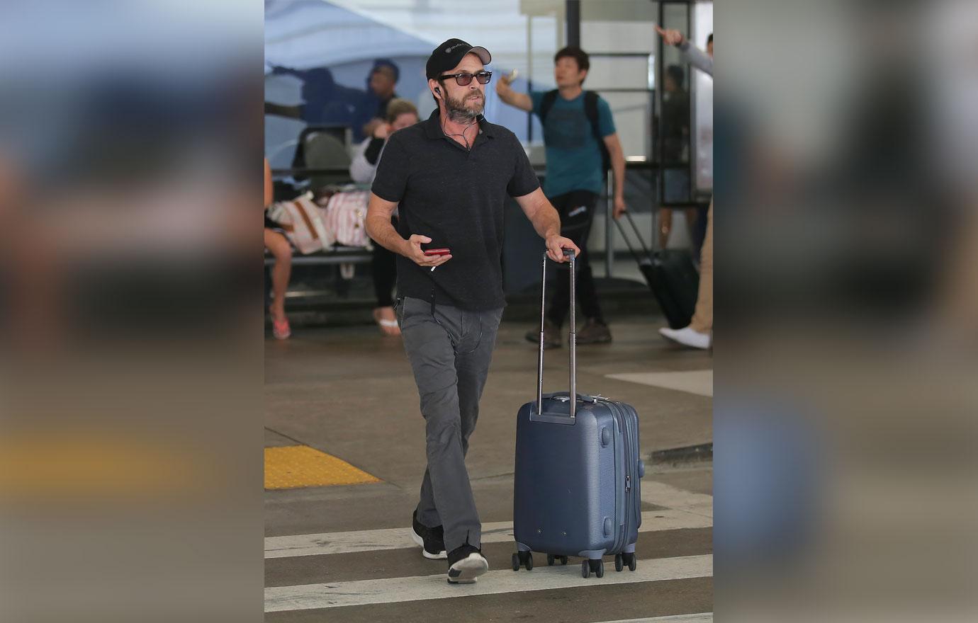 EXCLUSIVE: Luke Perry carries his own luggage at LAX airport