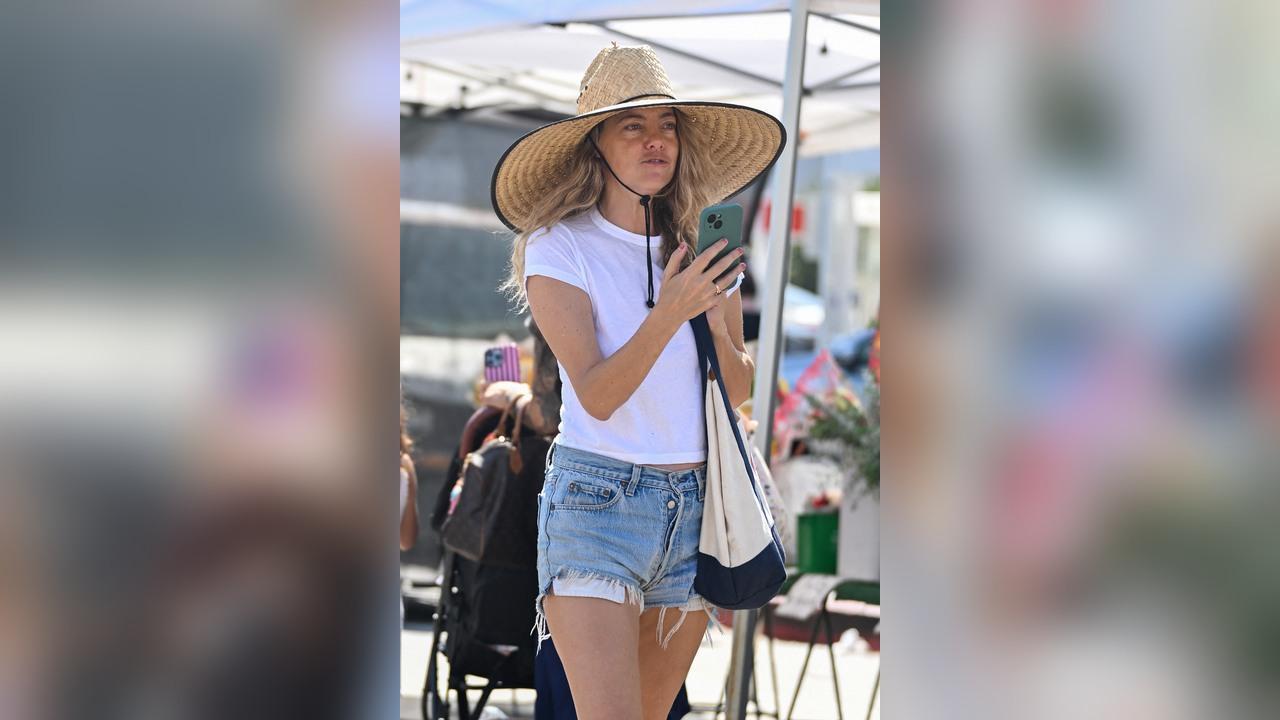 Image of Bijou Phillips kept things casual in denim shorts, a white T-shirt and oversized straw hat while browsing the outdoor market.