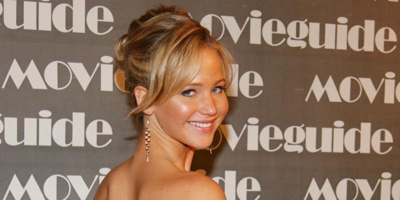 A young Jennifer Lawrence from 2007 smiles at the camera on a red carpet.