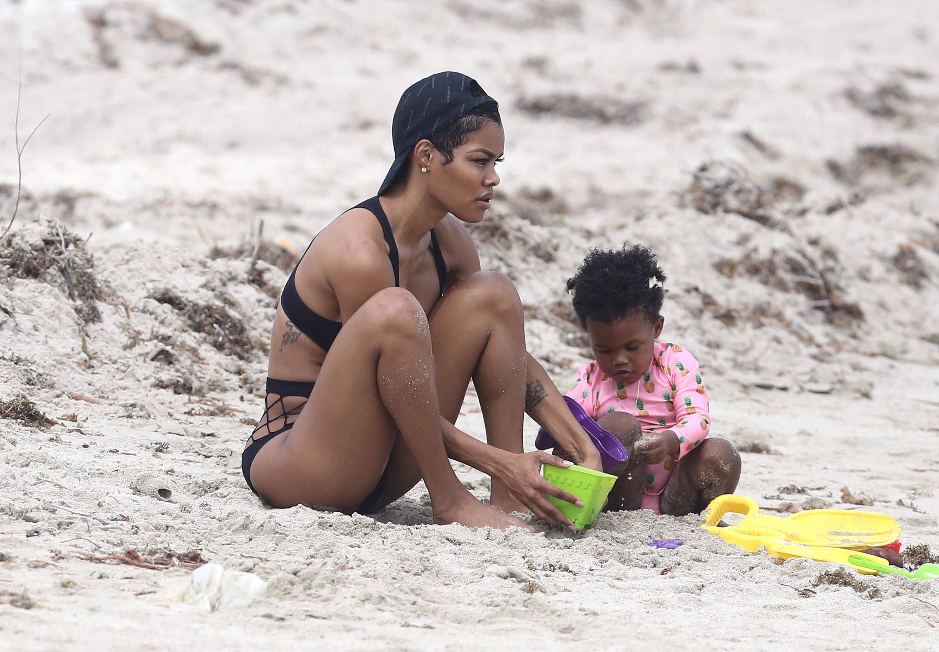 Singer Teyana Taylor shows off her abs in a black bikini on the beach in Miami