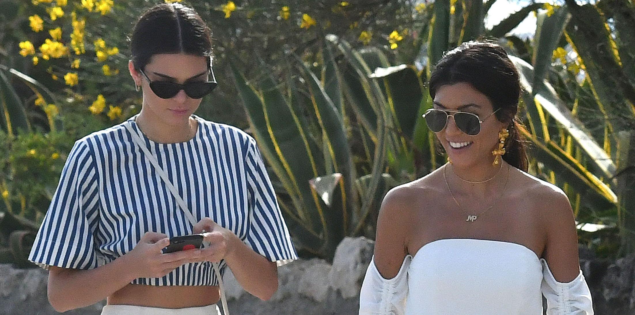 Kendall Jenner and Kourtney Kardashian walking on the beach during the 70th Cannes Festival