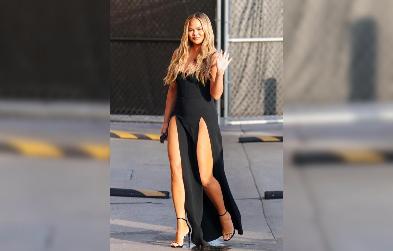 Chrissy Teigen puts on a leggy display with a high slit skirt that reveals  her Spanx