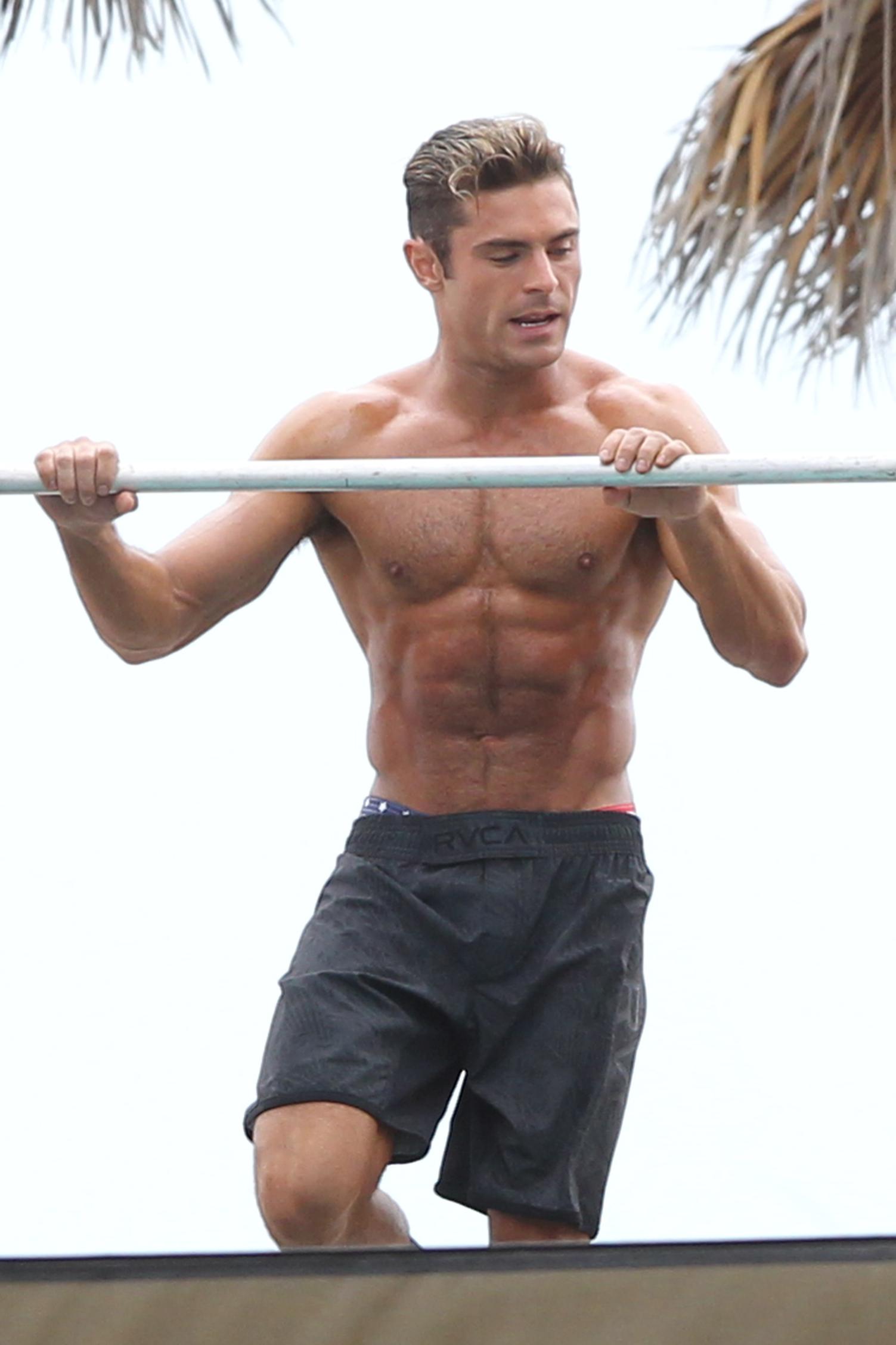 Zac Efron displaying his muscles doing pull ups in Miami Beach