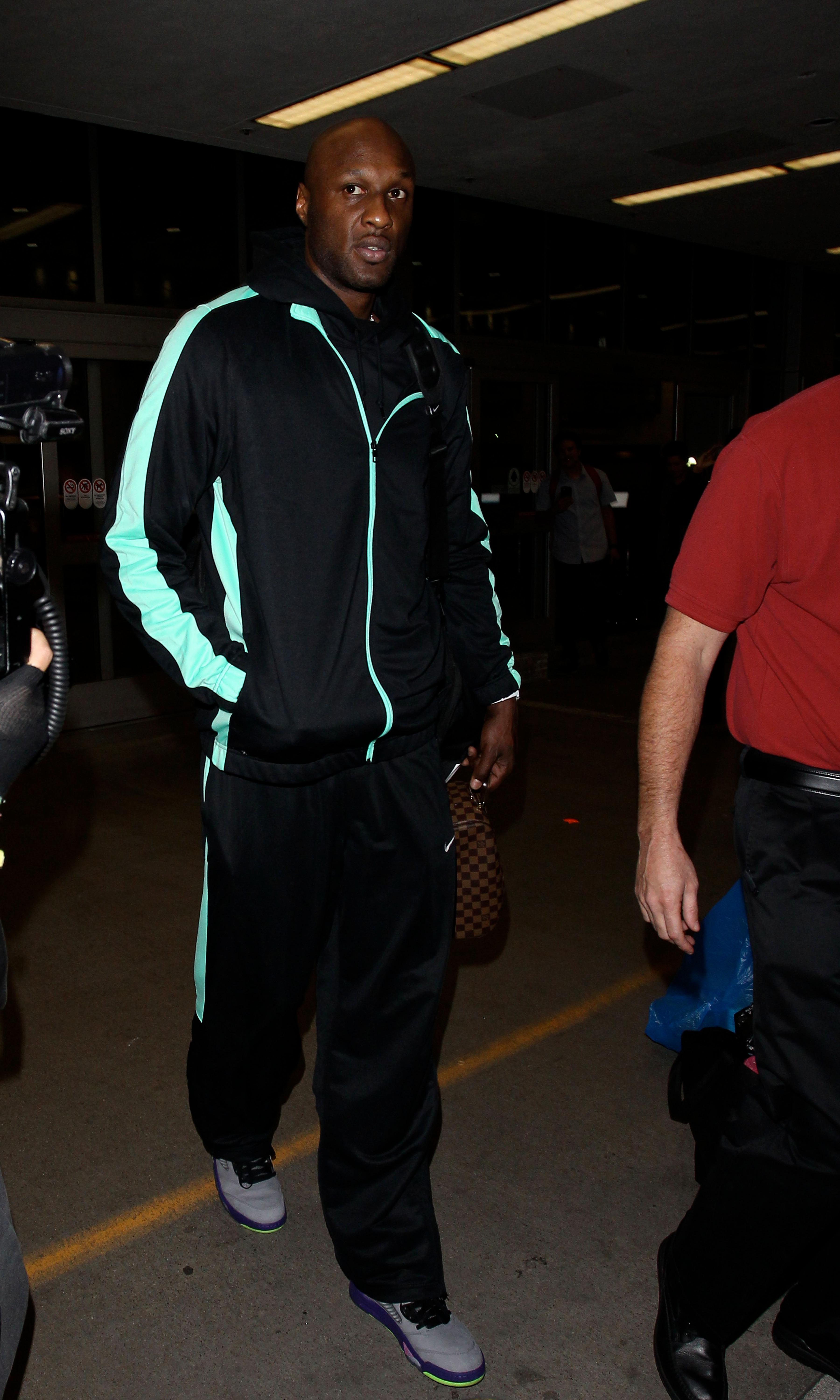 Lamar Odom is mobbed by photographers as he arrives in Los Angeles the day before Thanksgiving