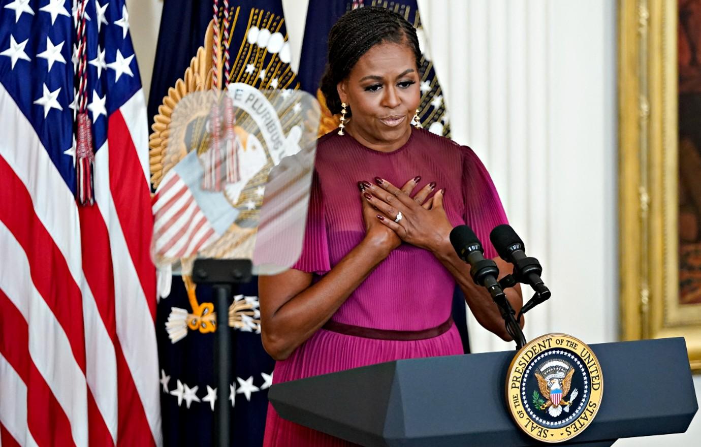 Photo of Michelle Obama with her hands on her chest.