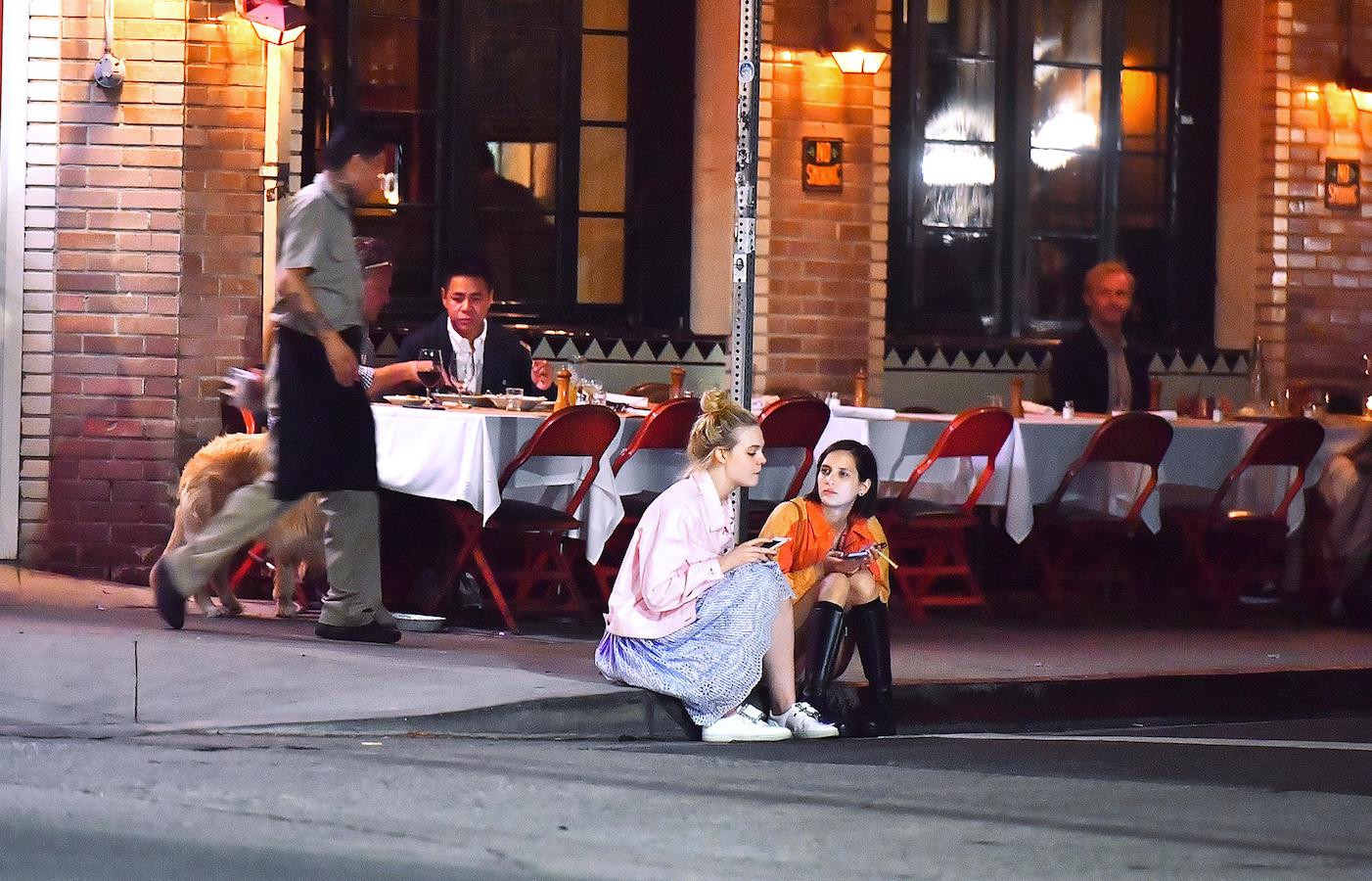 EXCLUSIVE: Elle Fanning sits on a curb and chats with a friend after dinner at Little Dom&#8217;s in Los Feliz, CA.