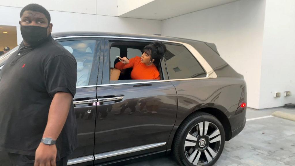 Cardi B leaning out of her SUV pointing finger