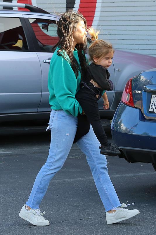 Kourtney Kardashian grins from ear to ear as she leaves the bowling alley with her family