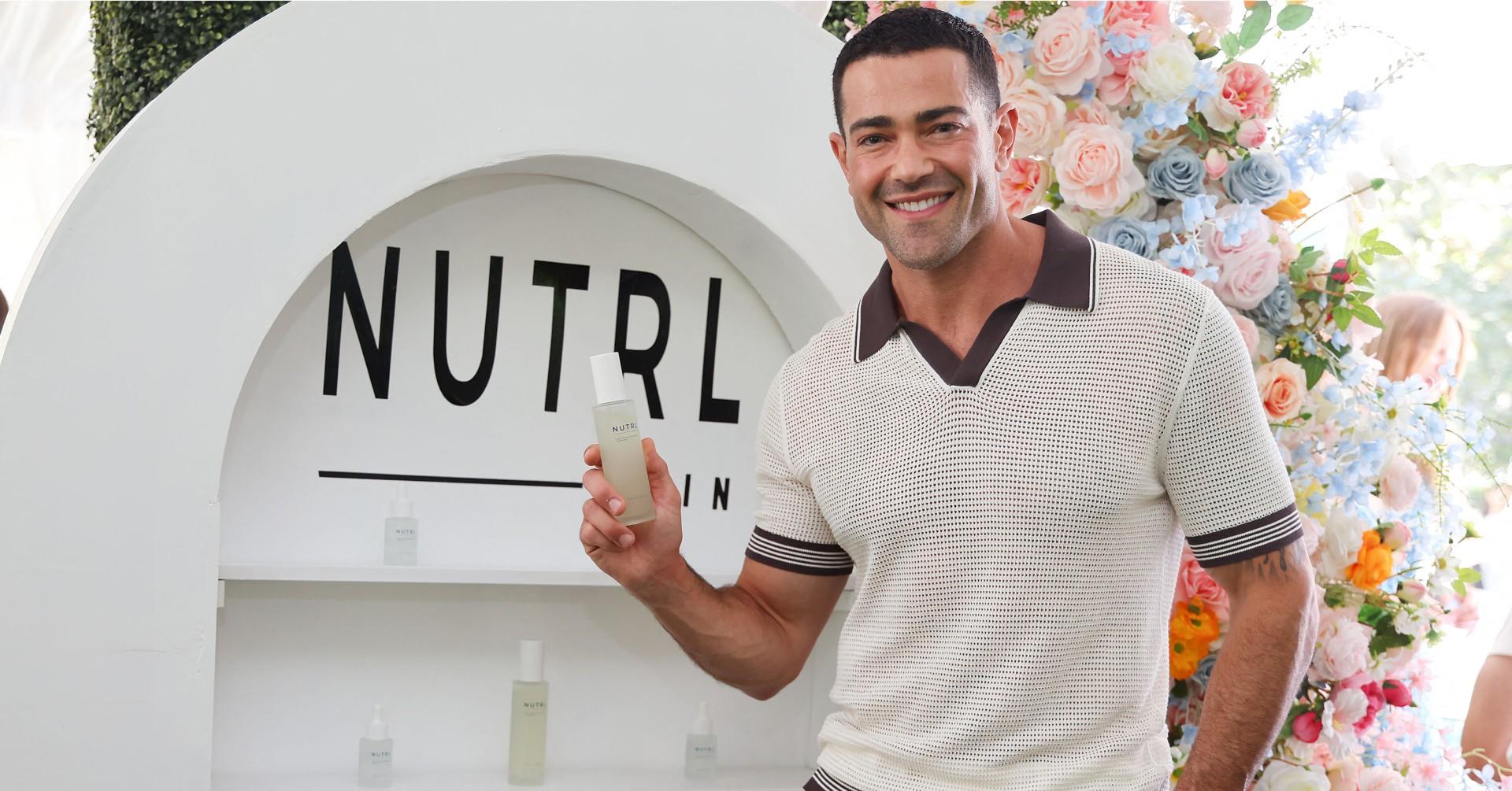 Photo of Jesse Metcalfe holding his product at Jill Zarin's Luxury Luncheon. 
