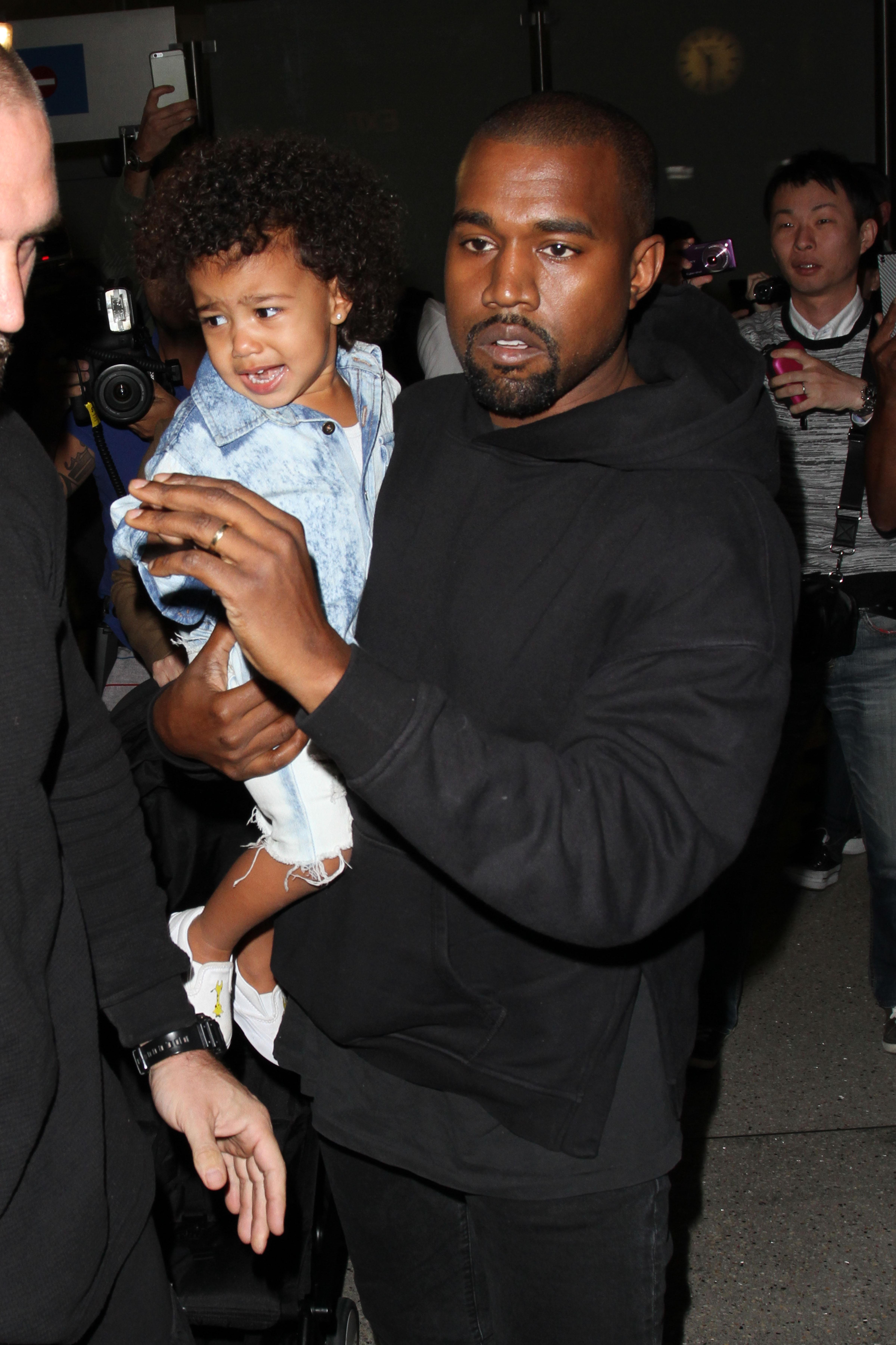 Kim Kardashian, Kanye West &amp; North West arrive in Los Angeles as they rush to a waiting SUV only seconds before a process server serves West with legal papers.