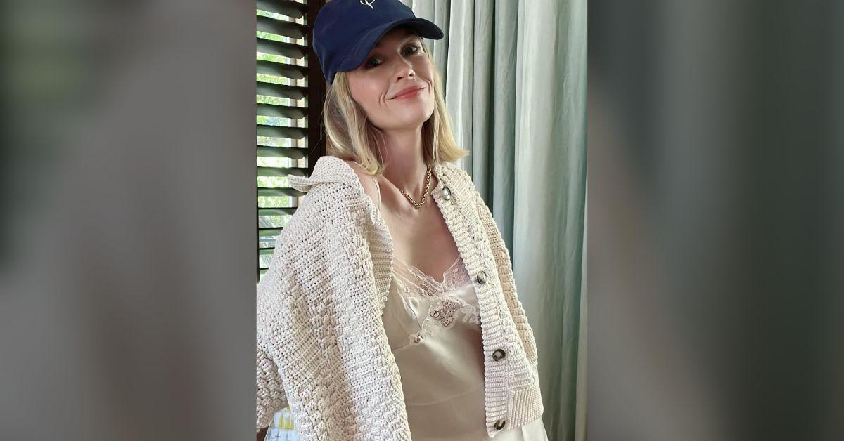 Image of January Jones cozied up in a cardigan and slip dress.