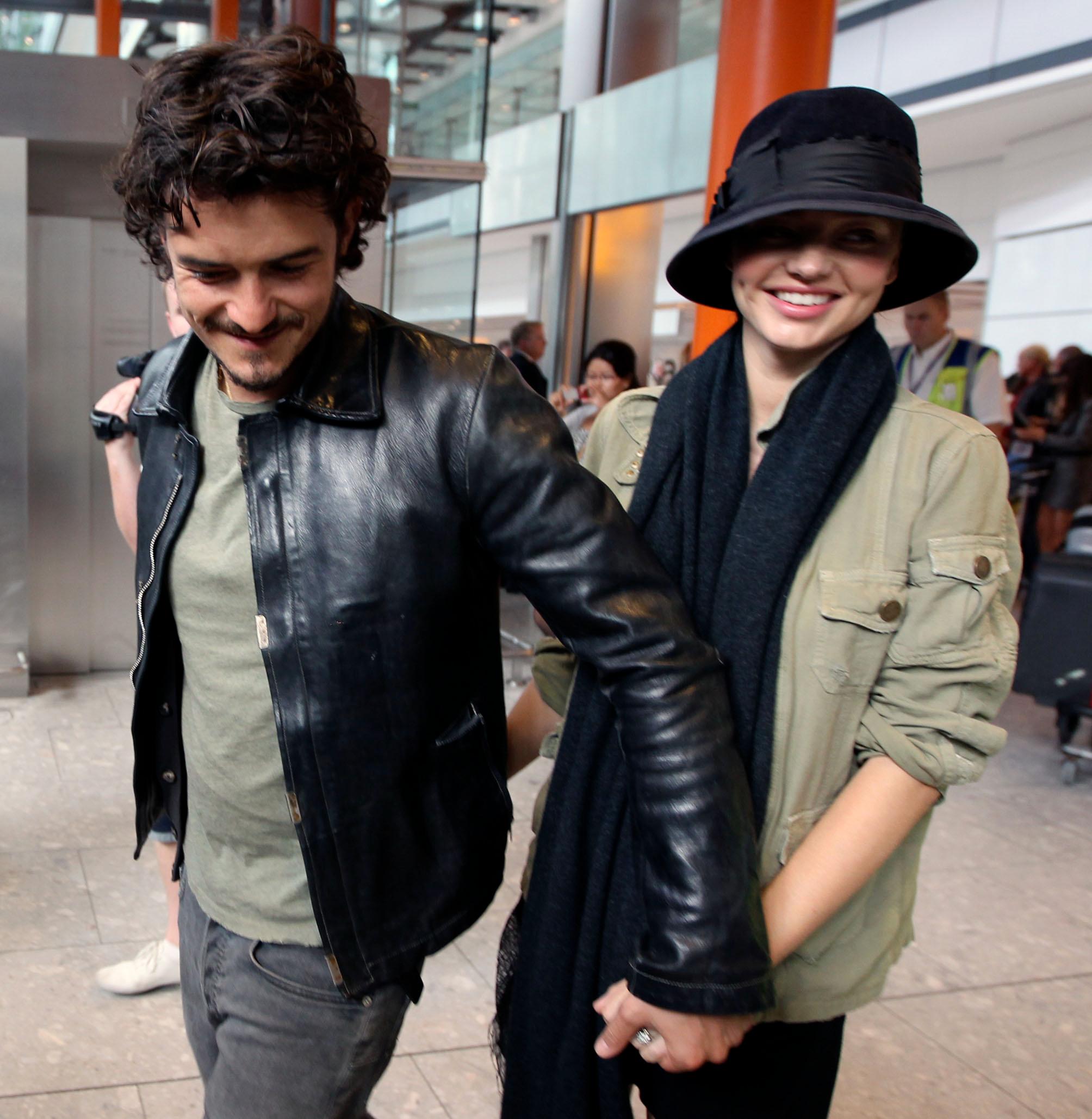 Orlando Bloom and wife Miranda Kerr arrive at heathrow airport