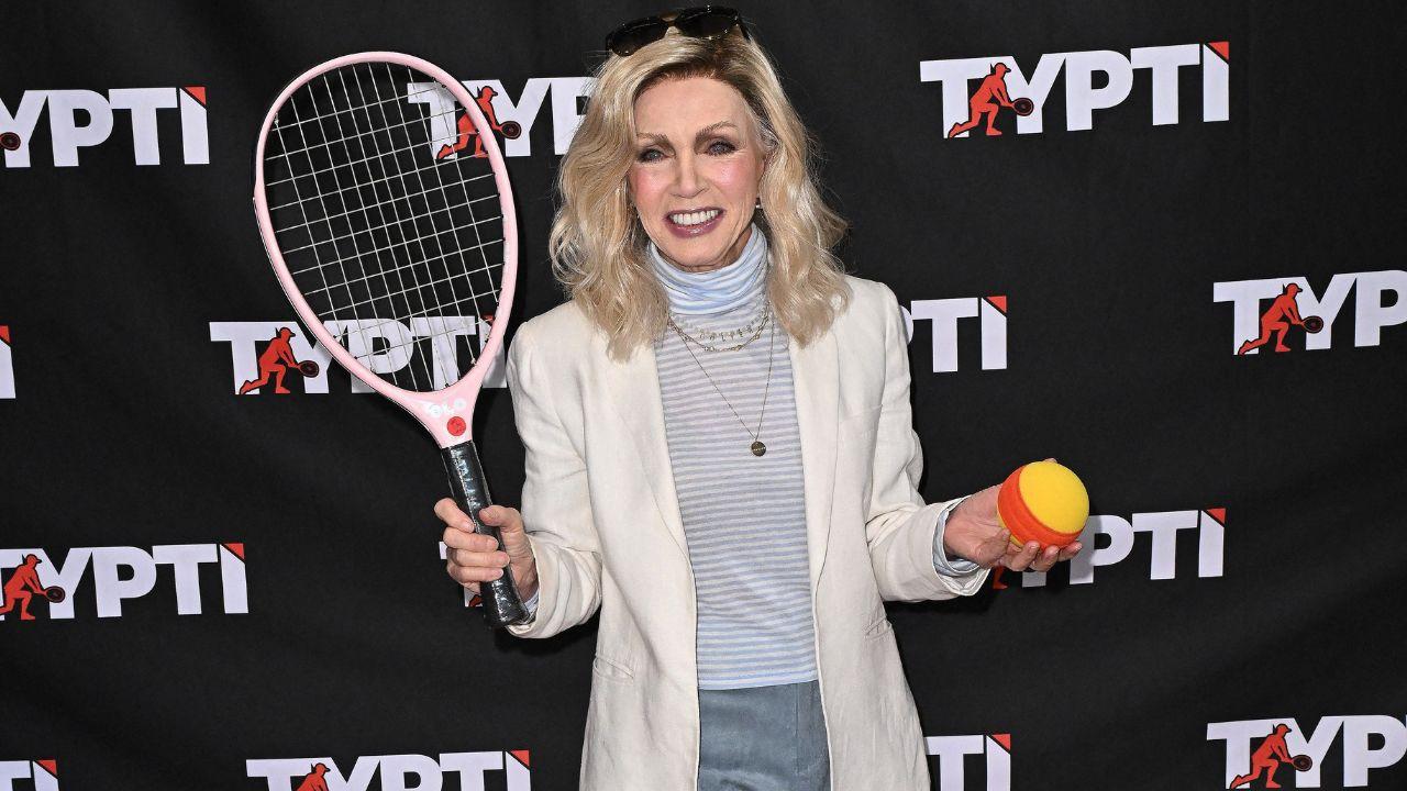 Image of Donna mills holding a tennis racket and ball.