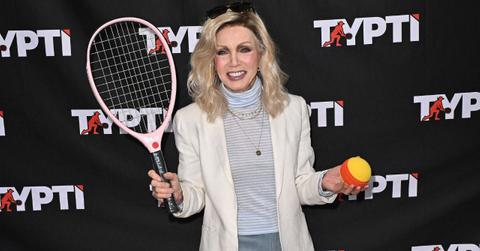 Image of Donna mills holding a tennis racket and ball.