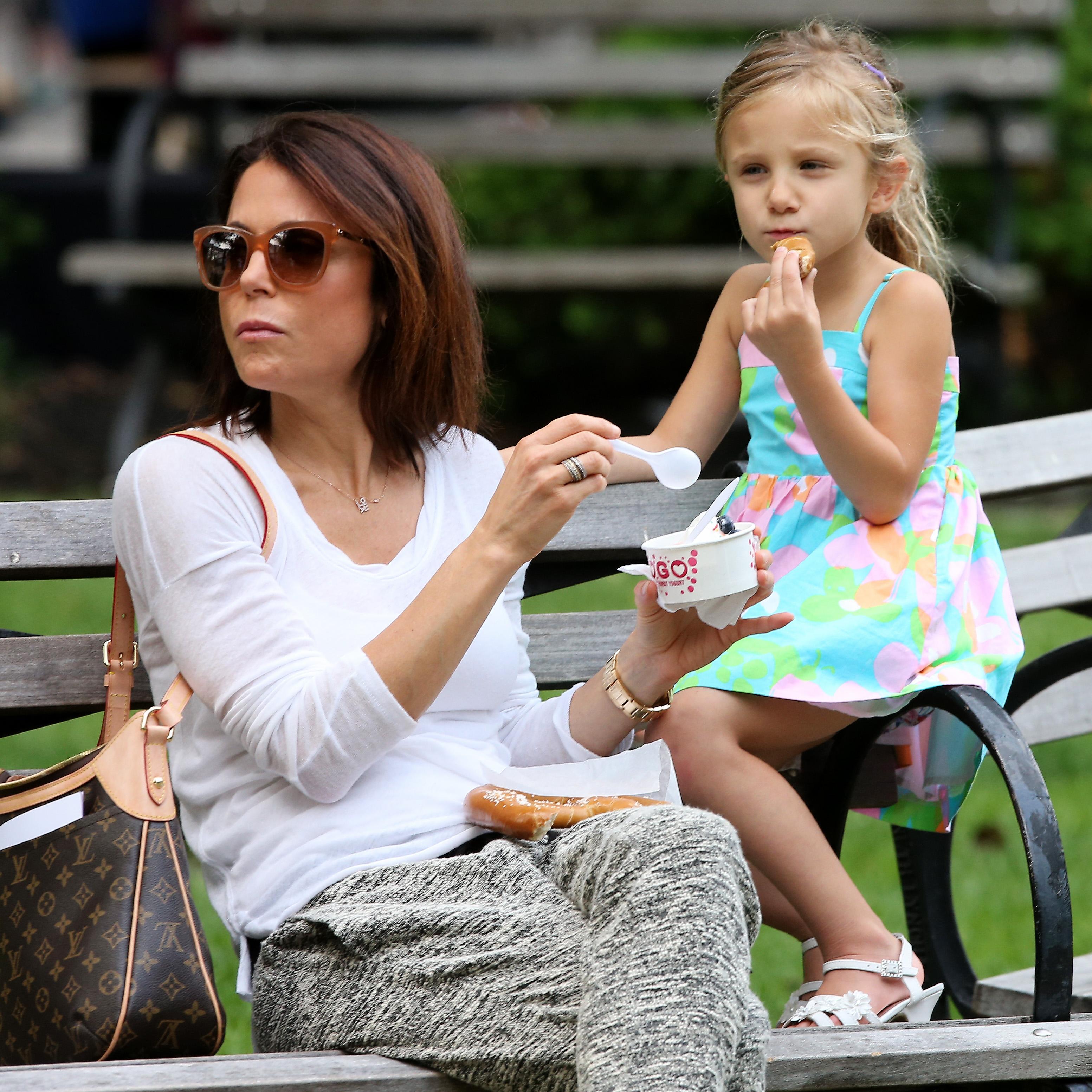 TV personality Bethenny Frankel and her daughter eat pretzels and frozen yogurt in the park, in Tribeca in New York City