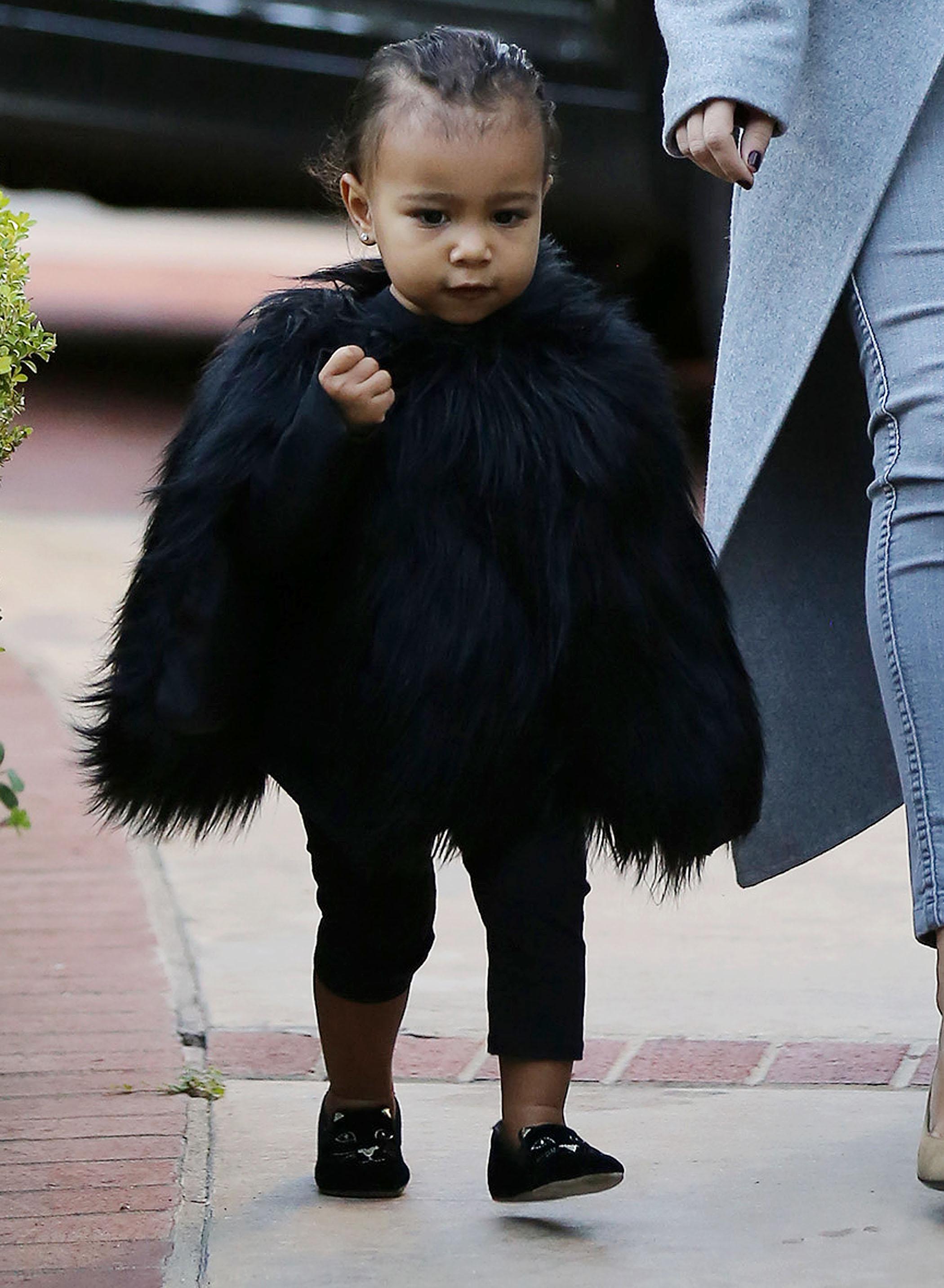 Kim Kardashian and her baby North, dressed in a black fur cape, arriving at a friend&#8217;s house in Beverly Hills ****NO DAILY MAIL SALES****